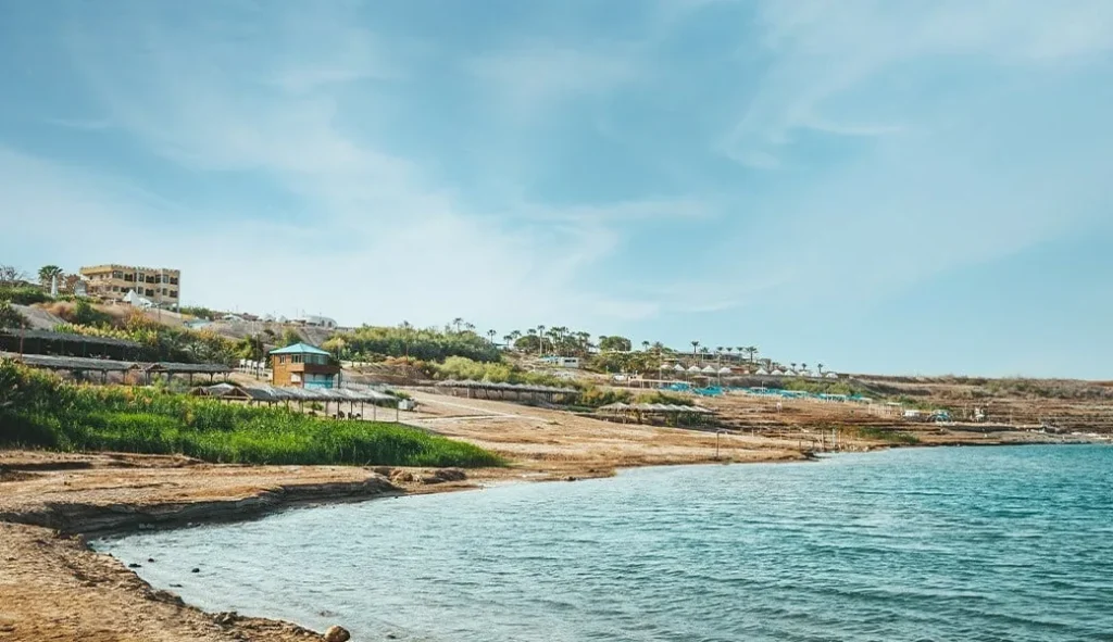 חוף ים המלח עם מים כחולים ושמשיות בכפר ביאנקיני