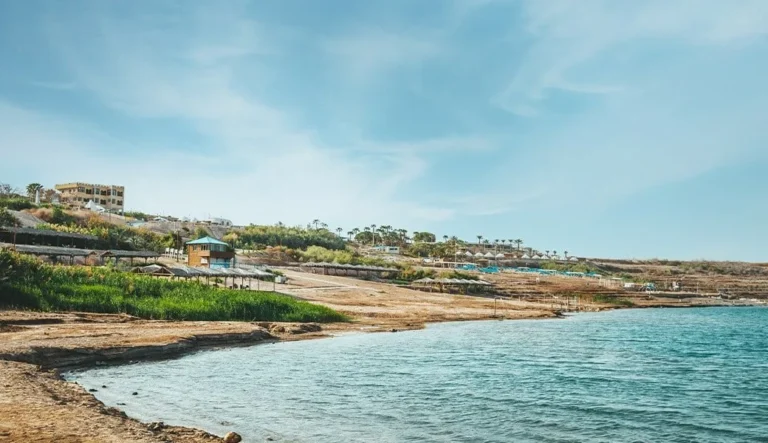חוף ים המלח עם מים כחולים ושמשיות בכפר ביאנקיני