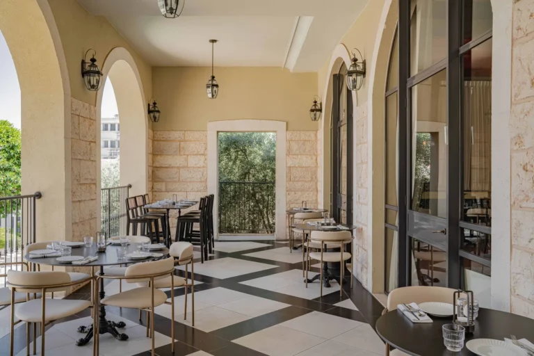 מרפסת מקומרת עם שולחנות אוכל במלון בוטניקה בחיפה