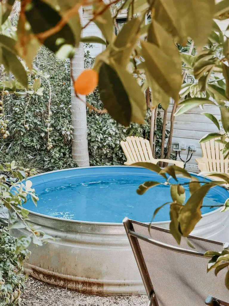 בריכת טבילה עגולה בגינה עם כיסאות עץ צהובים