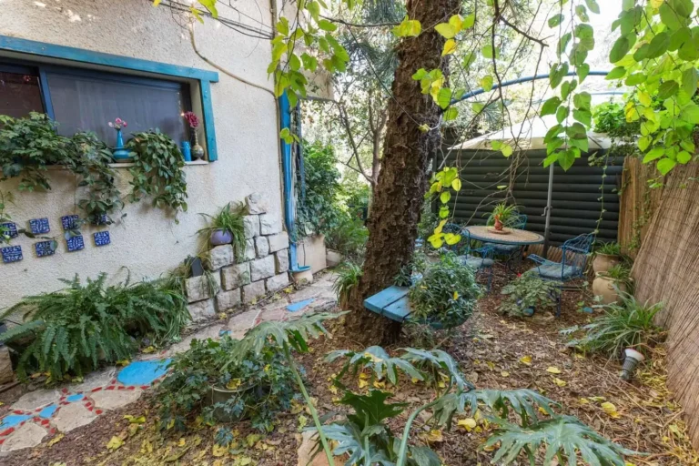 הבית והגינה עם פינת ישיבה בין העצים