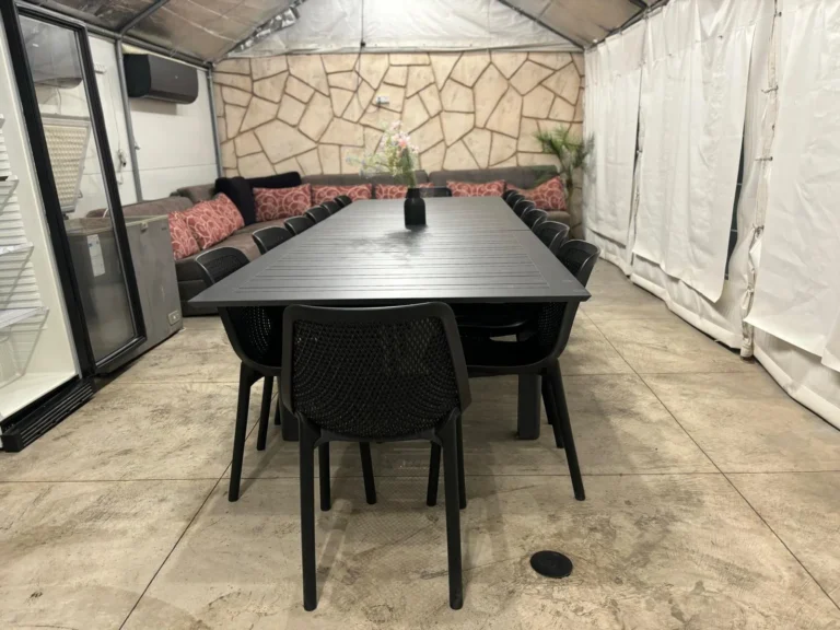 פינת אוכל גדולה מקורה עם ספות לצד הבית