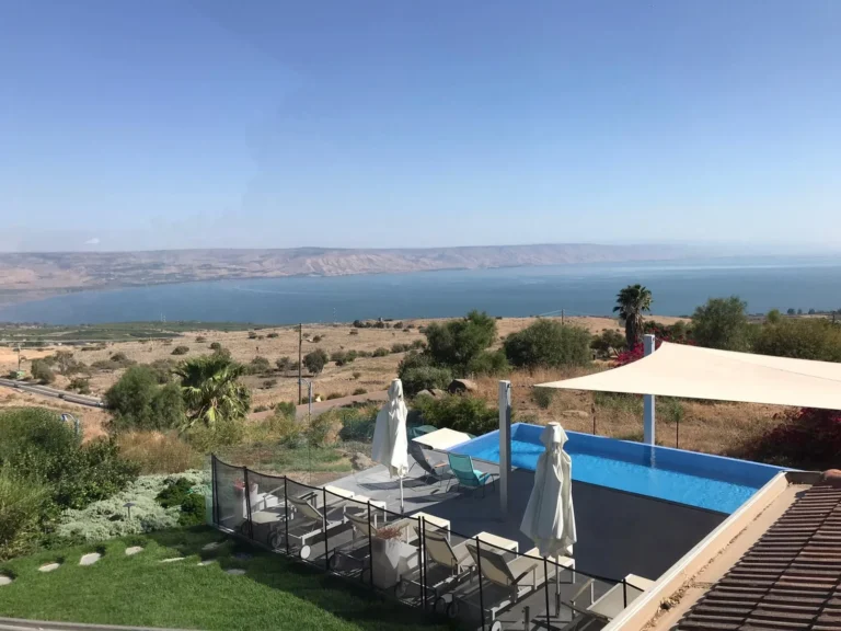 מרפסת הבריכה עם מיטות שיזוף ונוף רחב לכנרת