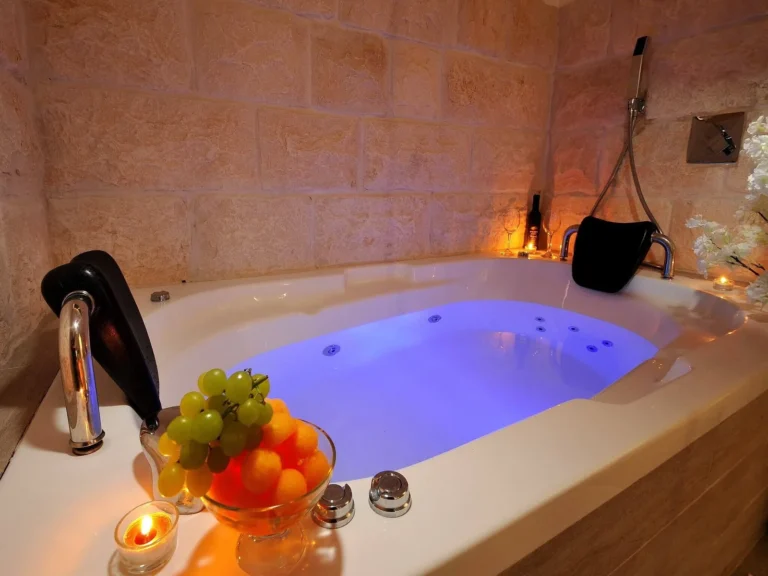 ג׳קוזי מואר עם קיר אבן ונרות