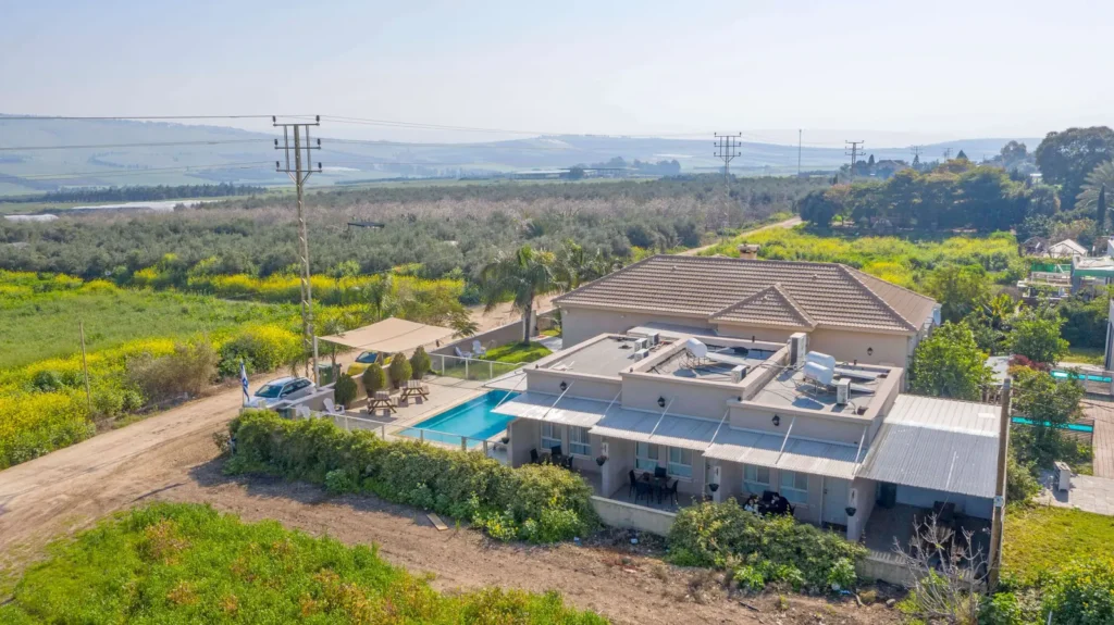 מבט מהאוויר על צימר בשדות יבניאל עם בריכה ושדות
