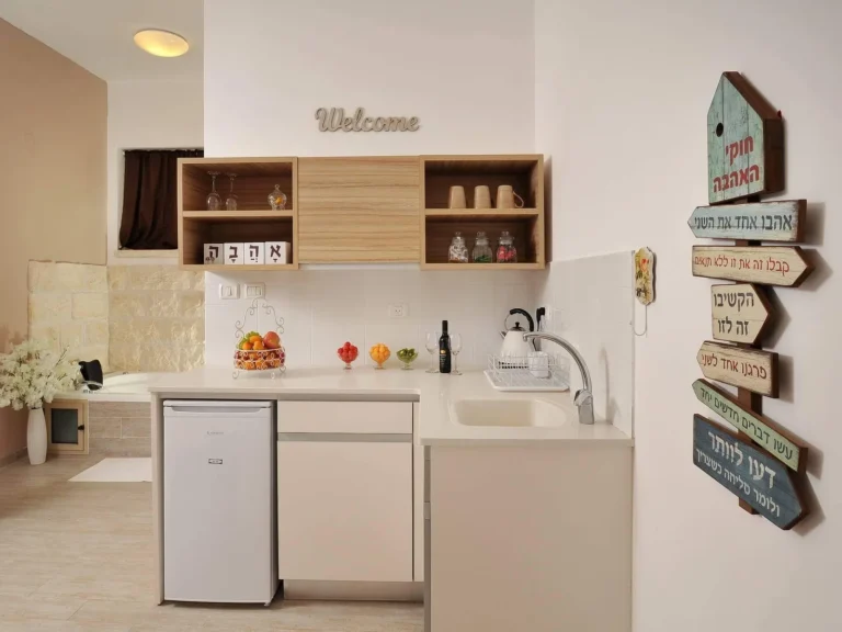 מטבחון לבן עם מקרר וקומקום